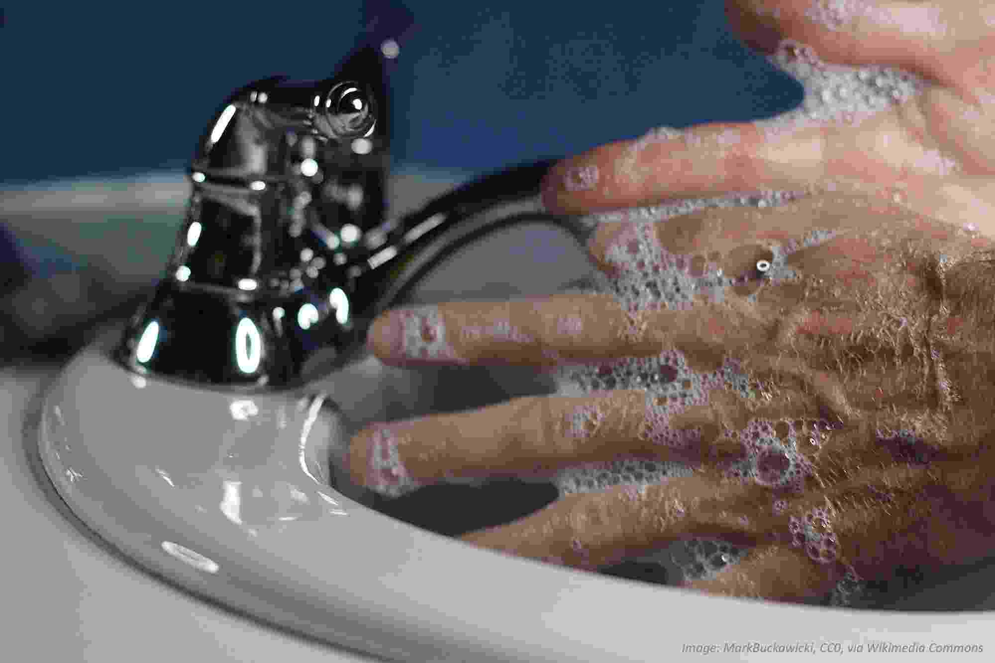Close-up of washing hands with soap under running water in a sink